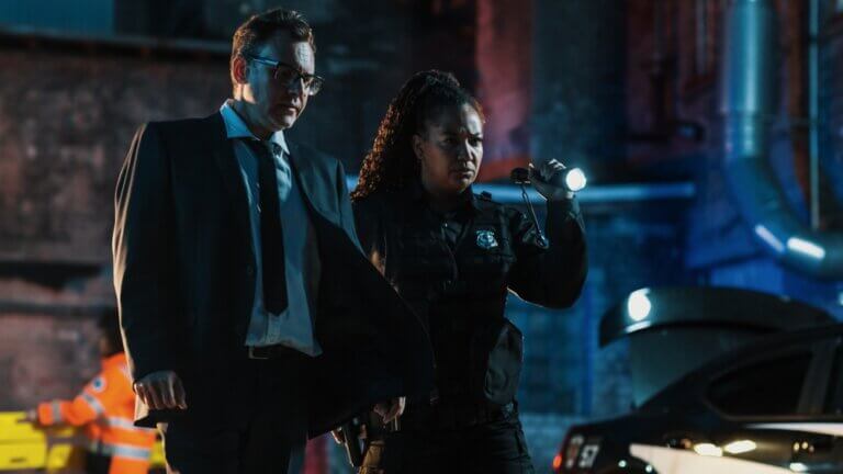 Male detective and female police officer arriving to a crime scene.