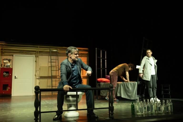 Actors on stage performing a scene in a play.