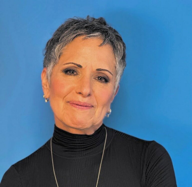 Casting Director Denise Chamian in a black sweater and gold necklace smiling.