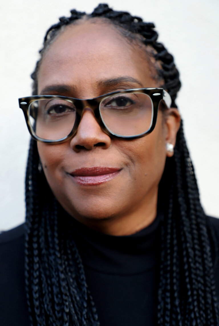 Casting Director Kim Coleman in a black sweater smiling.