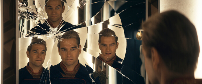 Antony Starr looking at a broken mirror with different expressions for each reflection.