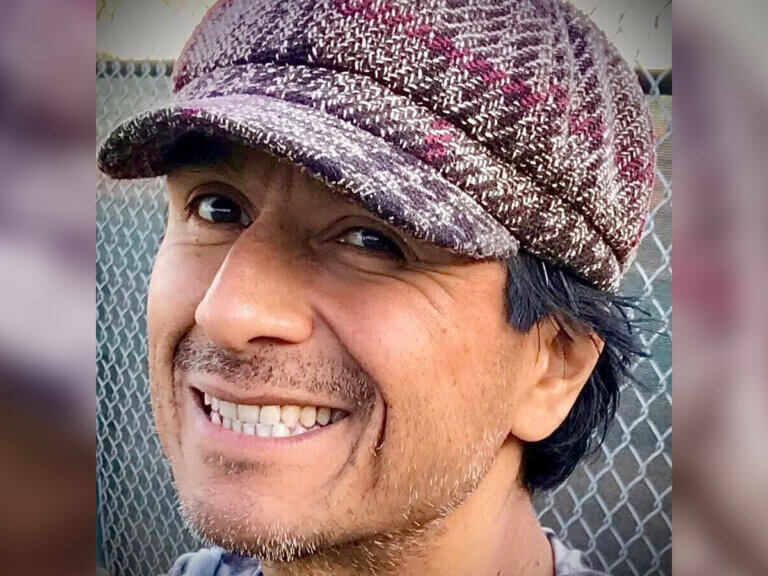Ernesto García-Orduña smiling in a knit beanie outside.