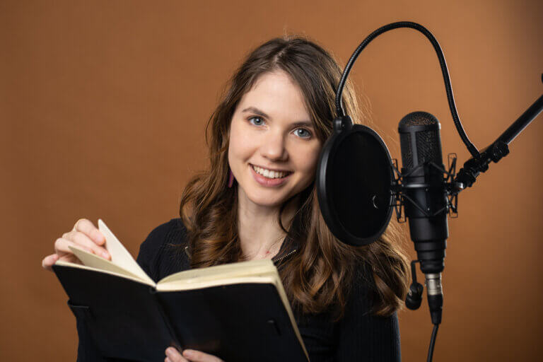Young female voice actor performing an audiobook narration