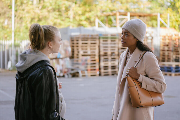 Naomie Harris and Natalie Dormer arguing in a parking lot.