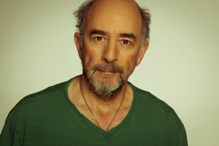 Richard Schiff smiling in a green shirt.
