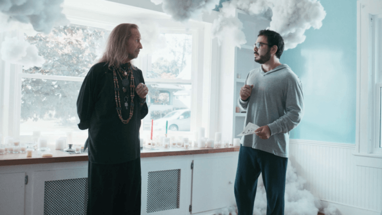 Grant Rosenmeyer and Paul Raci talking in the kitchen area of a house.