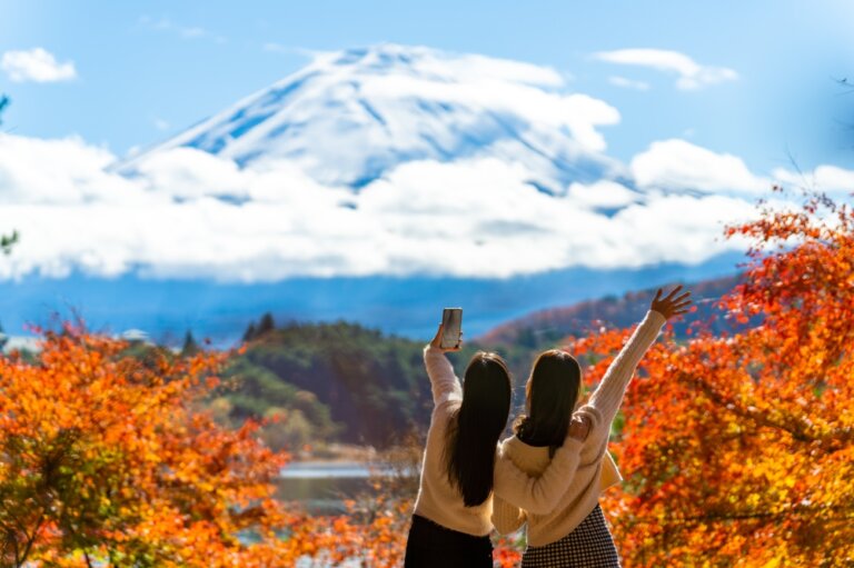 Two friends on a hike in fall discovering a mountain range.