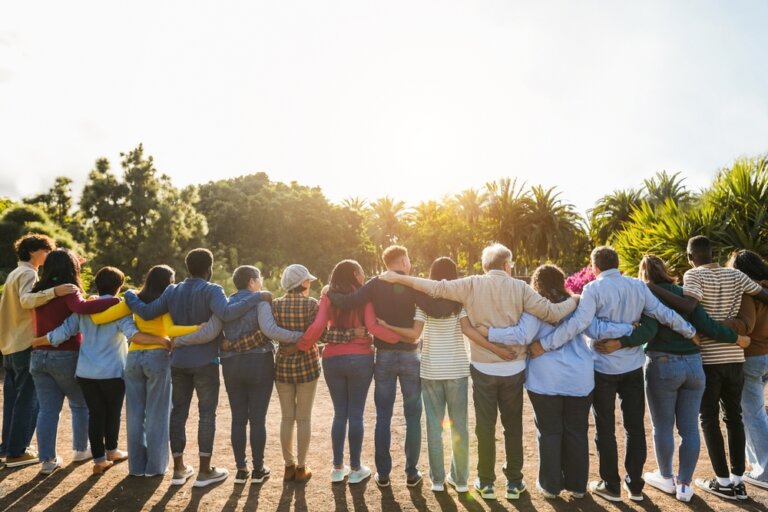 Diverse, multigenerational group of people supporting each other outside.
