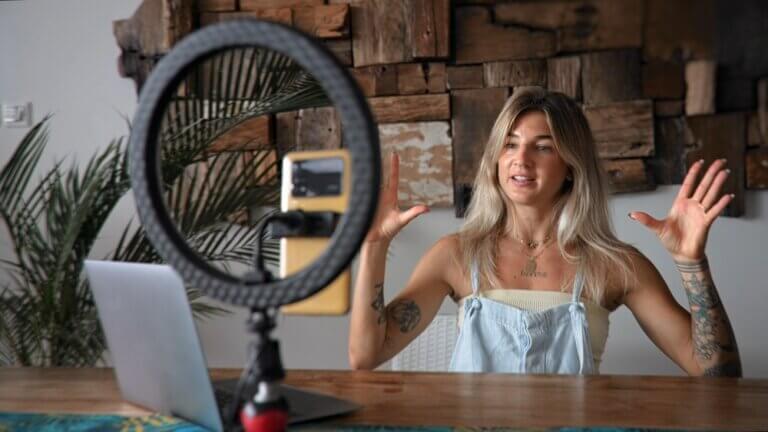 Actor recording a video on her phone for social media at home.