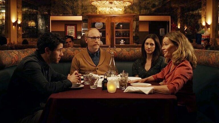 Nick Jonas and family sitting at a table in a restaurant.