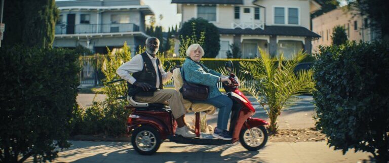 Richard Roundtree and June Squibb in THELMA, in a two-seater electric cart outside.