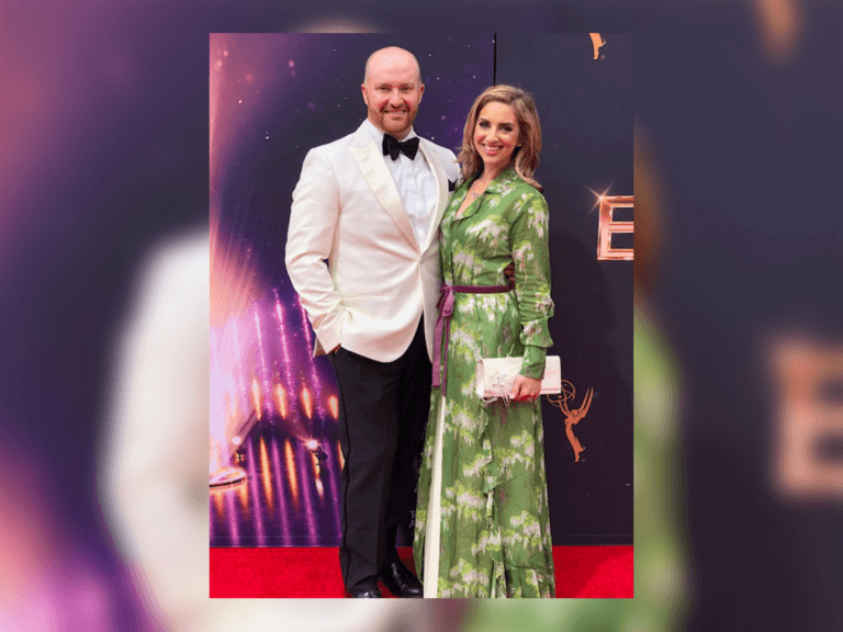 Chase Paris and his wife at a red carpet event in a white tuxedo and green dress.
