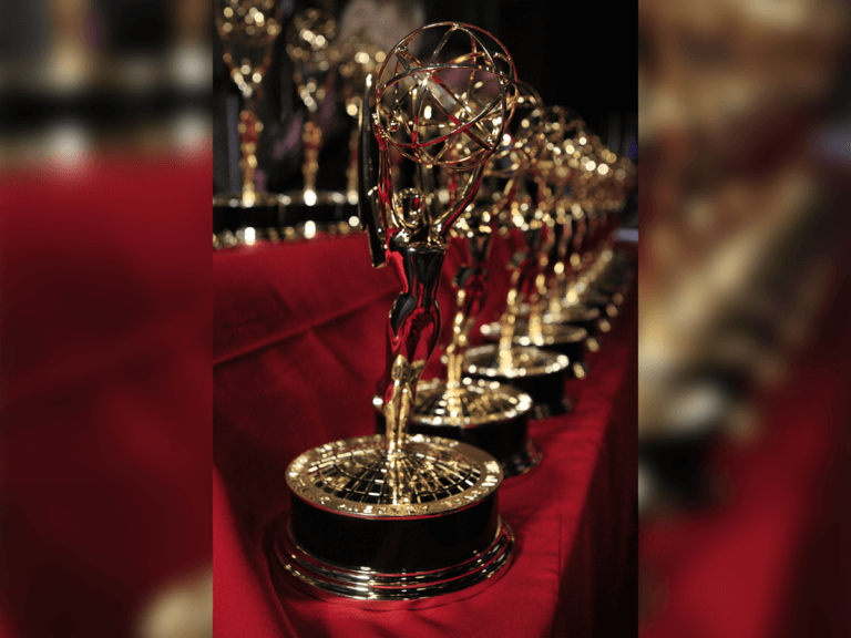 Emmy Award statues laid out across a red felt display.