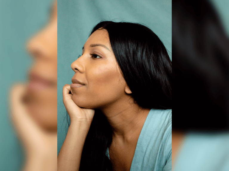 Casting Director Heather Basten smiling with her hand on her chin in a blue dress.