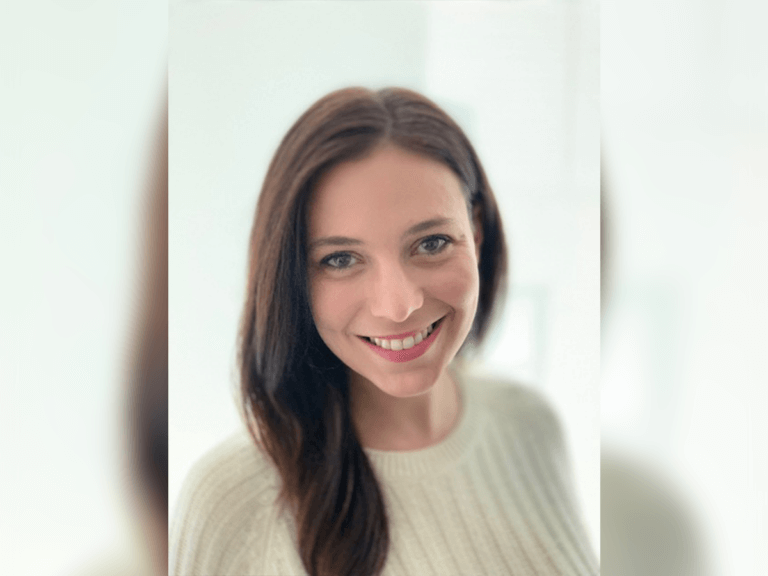 Neely Eisenstein smiling while wearing a white sweater.