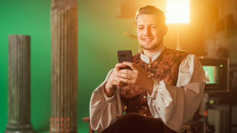 Actor looking t his phone on set for casting calls.