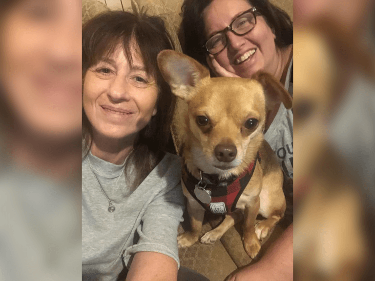 Andrea Kenyon, Randi Wells, and Randi's dog Jaxson "Christopher" Wells smiling on the couch.
