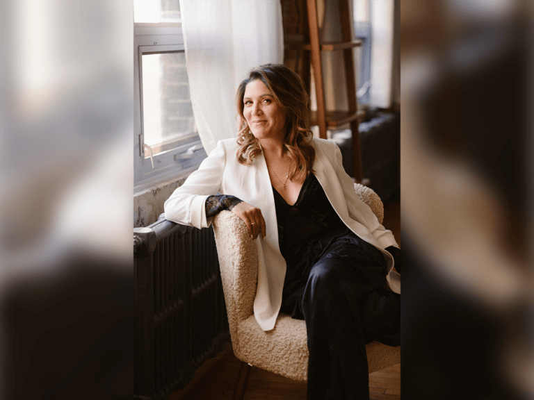 Casting Director Nicole Hilliard-Forde in a black sweater and white coat sitting inside.