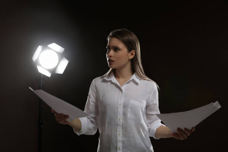 Actress deciding between two scripts to rehearse.