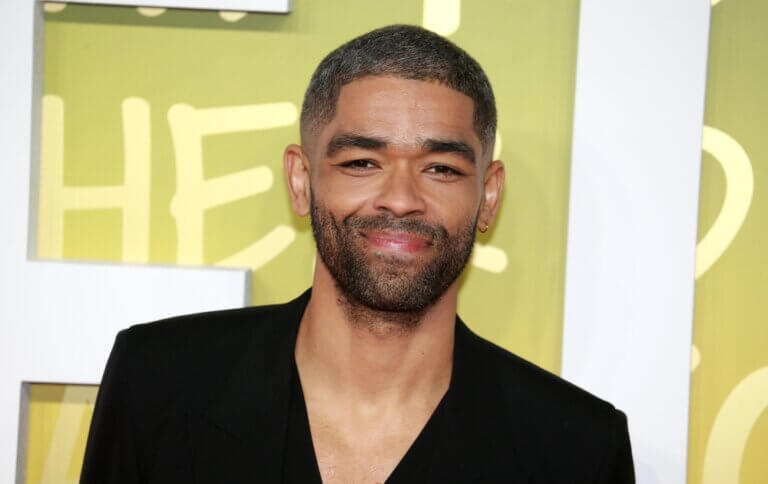 Kingsley Ben-Adir smiling in a black shirt at the premier for the film Bob Marley: One Love.