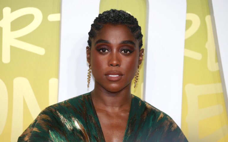 Lashana Lynch smiling in a green dress at a red carpet premiere for 'Bob Marley: One Love.'