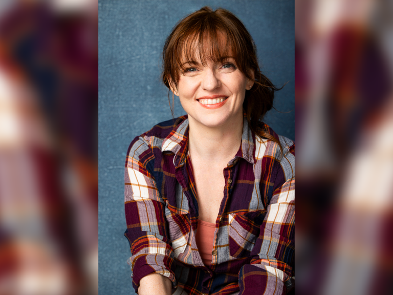 Christie Harms smiling in a flannel shirt.