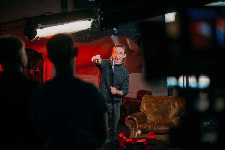 Stand up comedian pointing at a member of the crowd during a set.