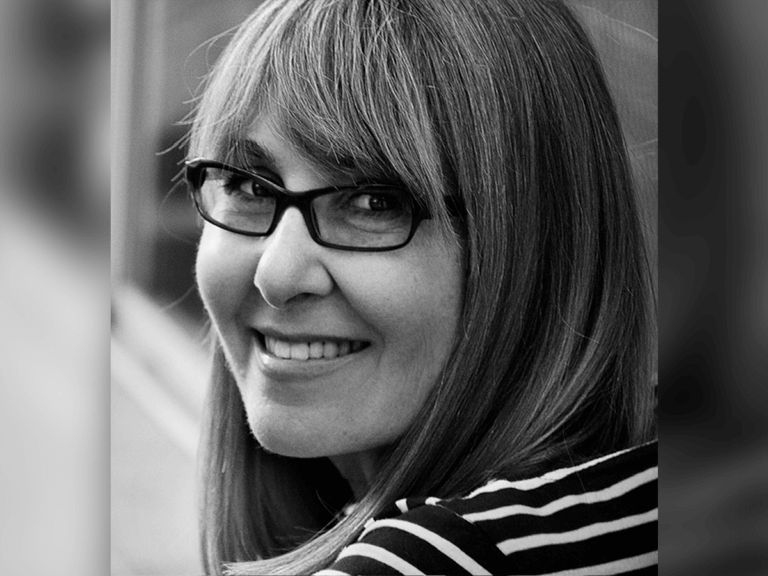 Casting Director Emily Schweber smiling in a striped sweater.