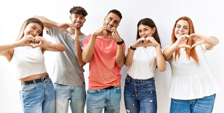 Group of happy diverse friends making hearts with their hands.