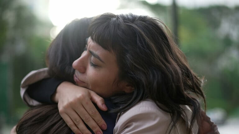 Woman supporting her friend in a time of need at the park.
