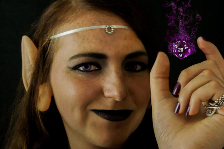 Female DnD player dressed as an elf using magic to levitate a D20 die.