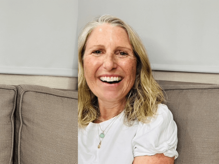 Casting Director Liz Dean sitting down on a blurry couch smiling.