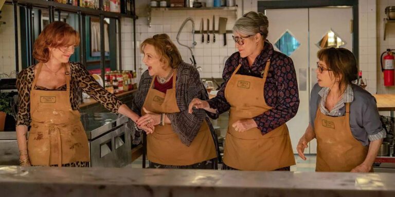 Susan Sarandon, Brenda Vaccaro, Lorraine Bracco and Talia Shire in the kitchen of an Italian restaurant wearing brown aprons.