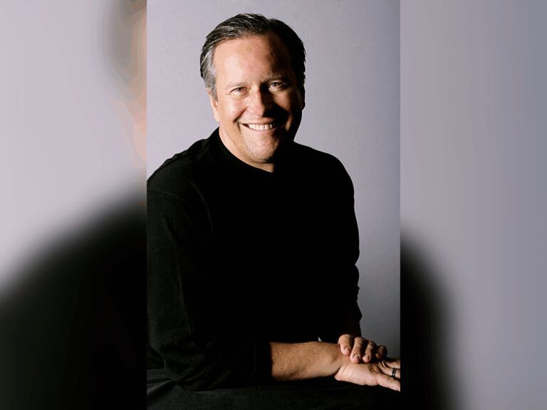 Pixar casting director Kevin Reher in a black sweater smiling.