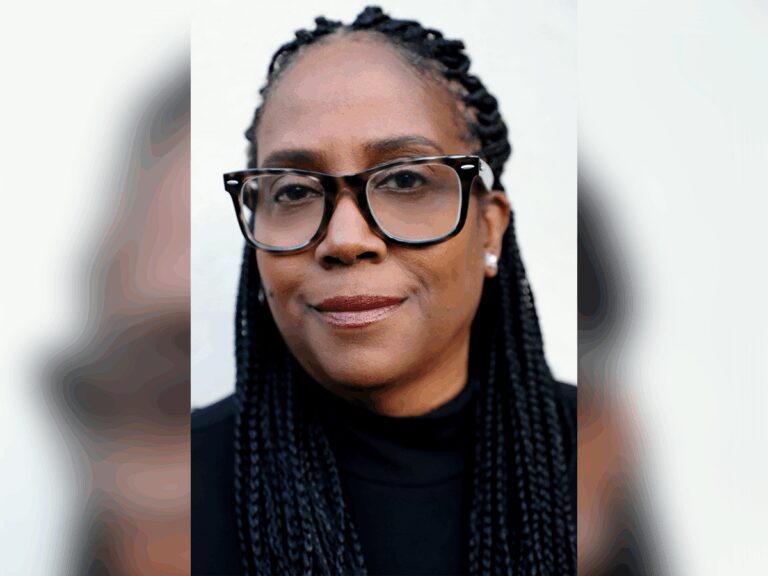 Casting director Kim Coleman looking sharp and smiling in a black shirt.