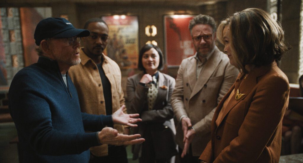 Ron Howard, Anthony Mackie, Seth Rogen and Catherine O’Hara arguing inside a studio while Chase Sui Wonders smiles.