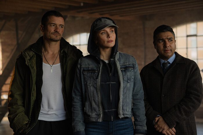 Bryce Dallas Howard, Orlando Bloom and Nick Mohammed in tough street clothes looking cool in an empty factory.