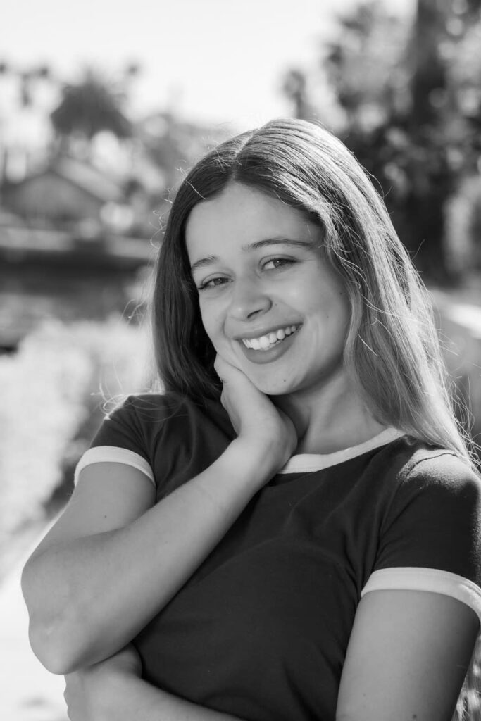 Black and white filter of Pauline Sala smiling, hand on her cheek.