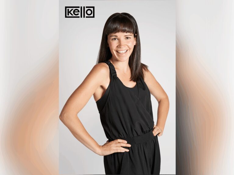 Kello Inclusive founder Katie MacMillan smiling in a black dress, hands on her hips with the Kello Inclusive logo above.