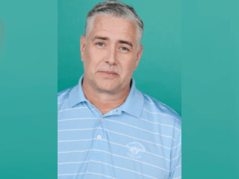 Mike Knox smiling in a blue and white striped polo shirt in front of a light green background.