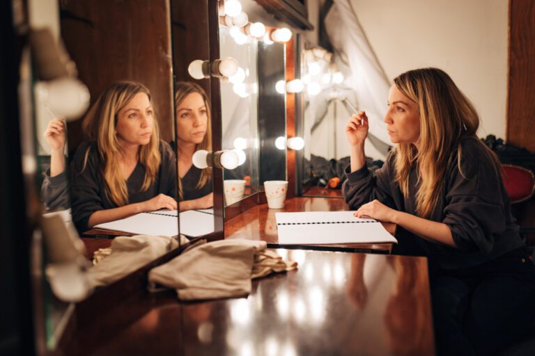 A theater actress sitting in the dressing room studying the script and getting into character.