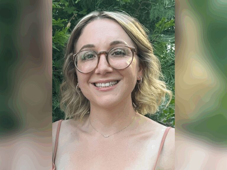 Casting director Jamie Ember smiling outside in a park, surrounded by trees.