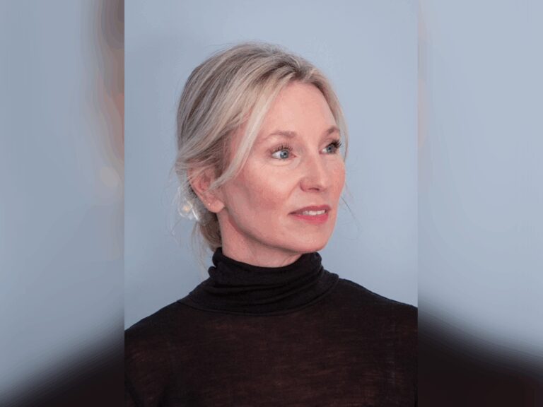 Casting Director Jessica Ronane in a black turtleneck smiling. inside.