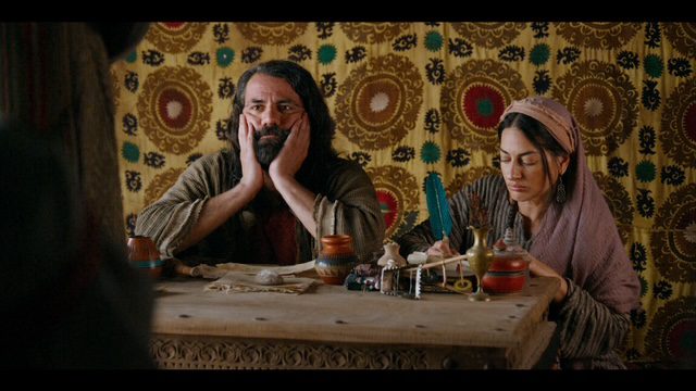 Wasim No'madi and Shereen Khan sitting at a table, No'madi with his hands over his cheeks.