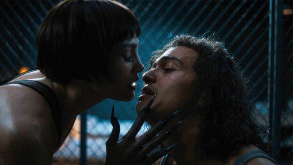 Jennifer Lopez with clawed hands embraces Tonatiuh in Kiss of the Spider Woman.